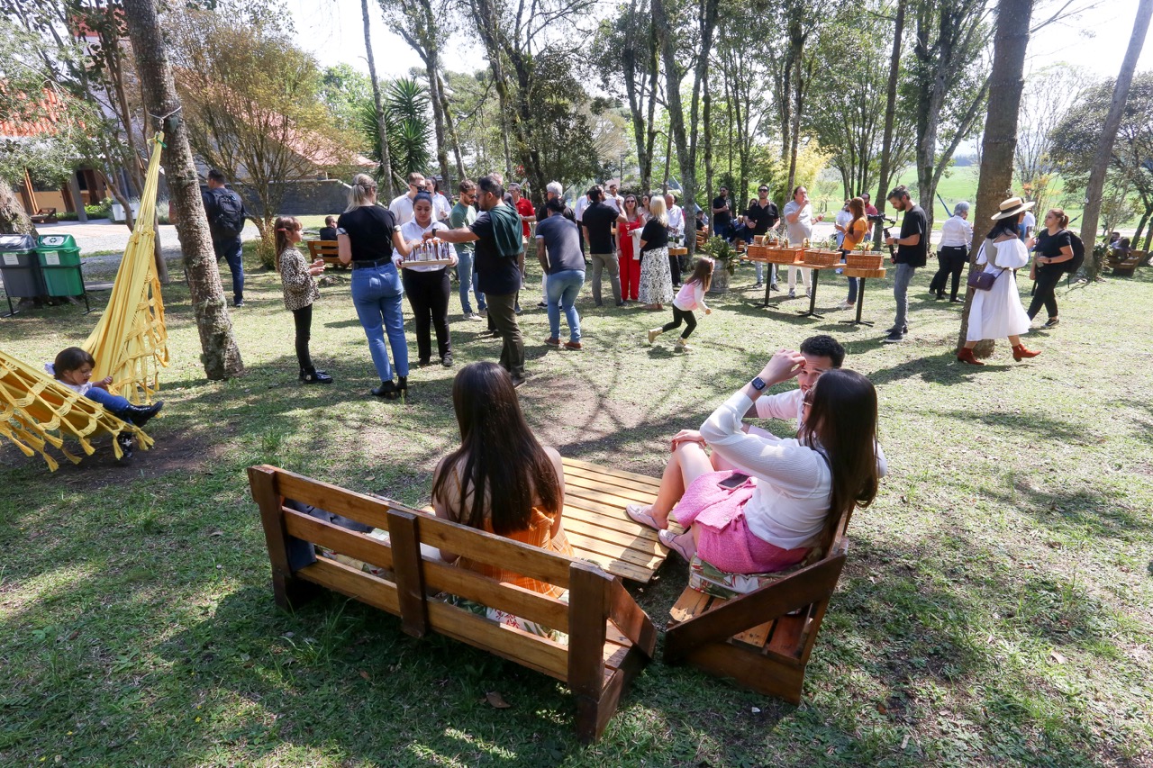Família reunida nos jardins da vinícola em uma tarde de sol